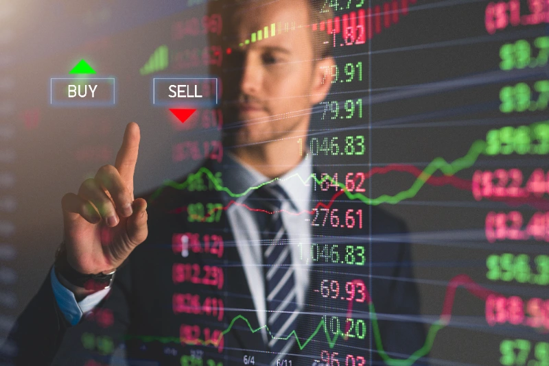 Hombre de negocios tocando una pantalla digital interactiva con datos bursátiles y botones de compra (Buy) y venta (Sell).