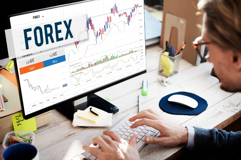 Persona frente a un ordenador trabajando con una plataforma de comercio de divisas (Forex).