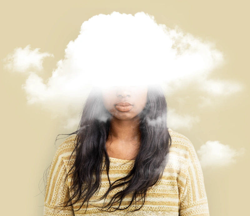 Una mujer tiene el rostro parcialmente cubierto por una nube blanca sobre un fondo beige.